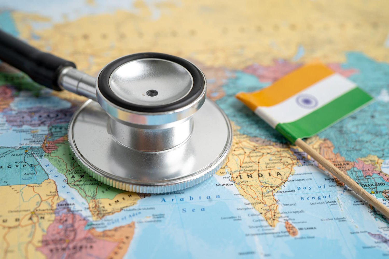 Stethoscope resting on a map of India beside the national flag